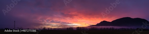 Panoramic View of Farm lands and Canadian Mountain Nature Landscape. Dramatic Winter Sunset. Located near Chilliwack and Abbotsford  British Columbia  Canada.