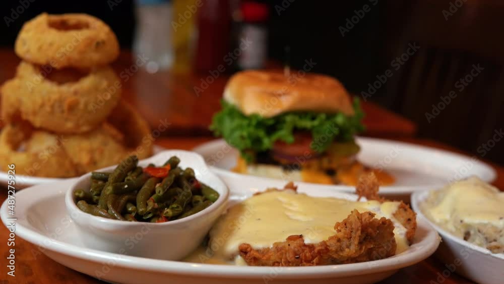Close up shot of Chicken Fried Steak,Onion Rings and Burger served in luxury restaurant Close up shot of Chicken Fried Steak,Onion Rings and Burger served in luxury restaurant