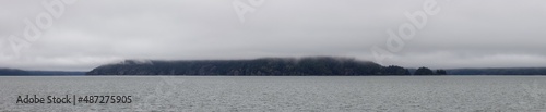 Echo Island in Harrison Lake during Cloudy and Foggy Winter Day. Panoramic Canadian Nature Landscape. Harrison Hot Springs, British Columbia, Canada. Background Panorama