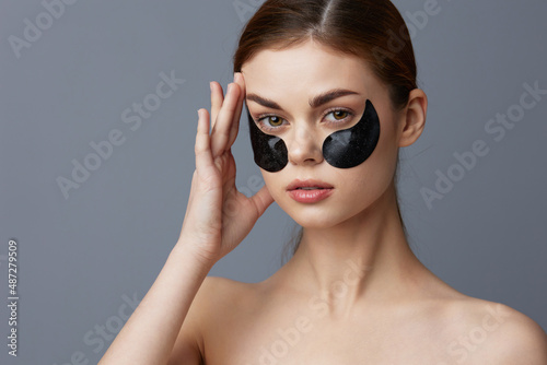pretty woman with patches on the face clean skin health rejuvenation Gray background