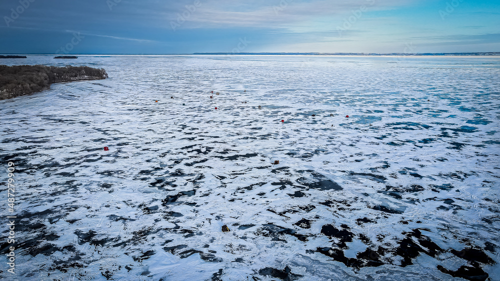 The point of land reaches the frozen lake with blue sky The point of land reaches the frozen lake with blue sky