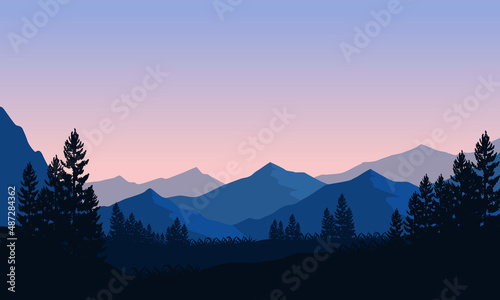 Beautiful mountain view from the edge of the forest at dusk with the silhouette of the shady trees around