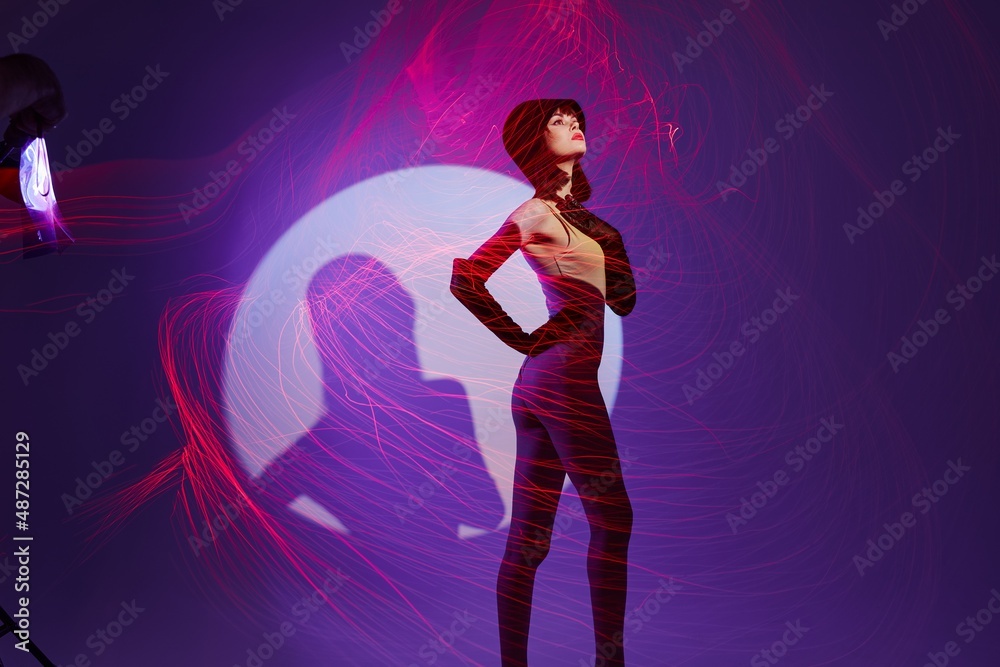 Beautiful fashionable girl posing studio light neon purple background unaltered