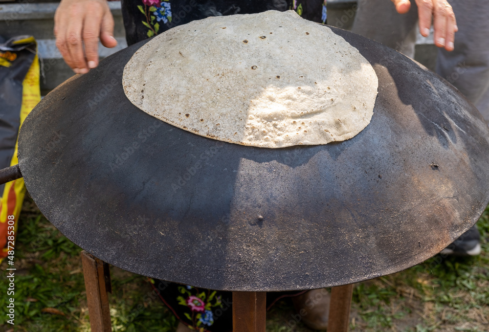 Arabian female person prepare flatbread (other names is pita, lavash
