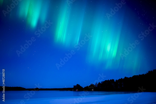 Northern lights dancing over frozen lake in Farnebofjarden national park in north of Sweden. © Conny Sjostrom