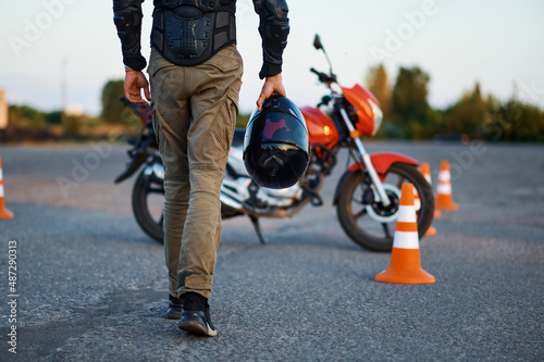 Obraz na plátne Male person holds helmet, motorcycle school