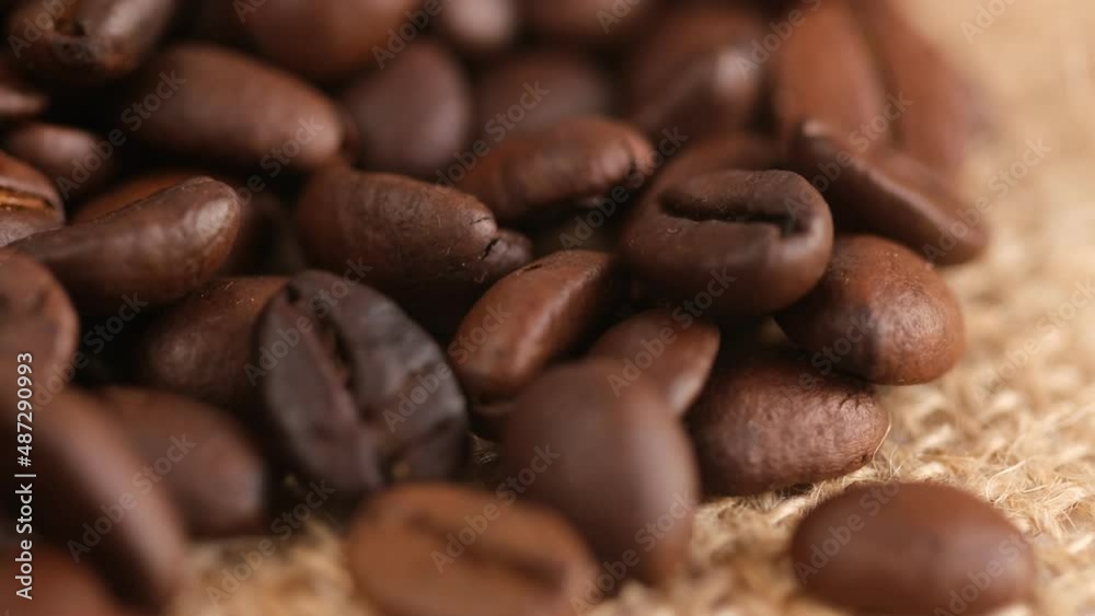 Coffee beans on canvas, cam moves , close up.Freshly roasted coffee on canvas.Coffee beans in the bag.A handful of coffee beans on a brown canvas. Coffee beans on canvas, cam moves , close up.Freshly roasted coffee on canvas.Coffee beans in the bag.A handful of coffee beans on a brown canvas.