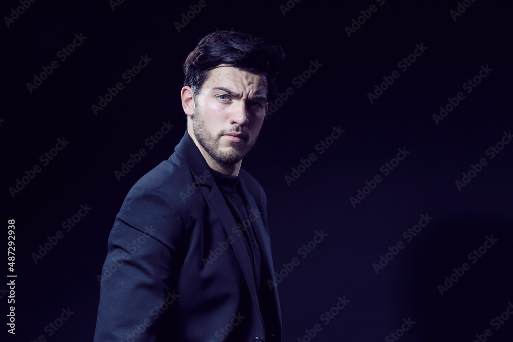 Handsome Caucasian Brunet Businessman Wearing Black Suit Posing With Straight Look Against Black Studio Background