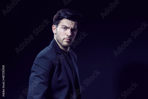 Handsome Caucasian Brunet Businessman Wearing Black Suit Posing With Straight Look Against Black Studio Background © danmorgan12