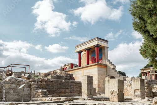 Minoan palace Knossos at Heraklion, Crete island, Greece. North Entrance with charging bull fresco and three red columns against a dramatic cloudy sky photo