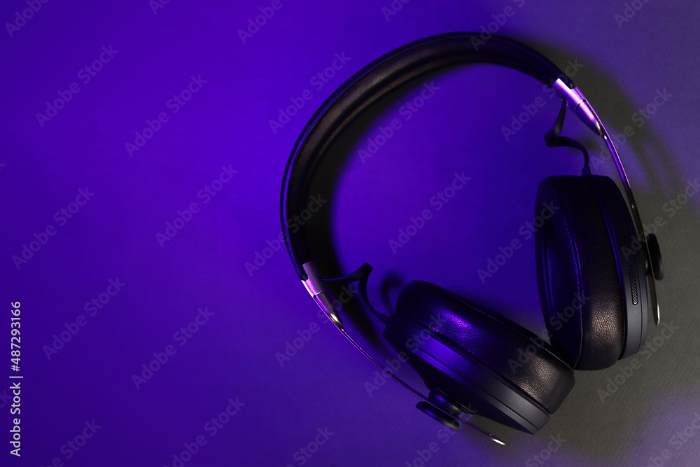Full-size wireless headphones in the ultraviolet light of the club Full-size wireless headphones in the ultraviolet light of the club