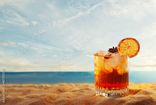 Wallpaper Mural Orange cocktail on yellow sand. Alcoholic drink with ice, orange and cinnamon close up. Sunset, sea and sky in the background. Copy space and free space near the glass. Torontodigital.ca