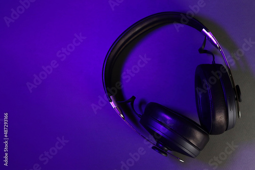 Full-size wireless headphones in the ultraviolet light of the club