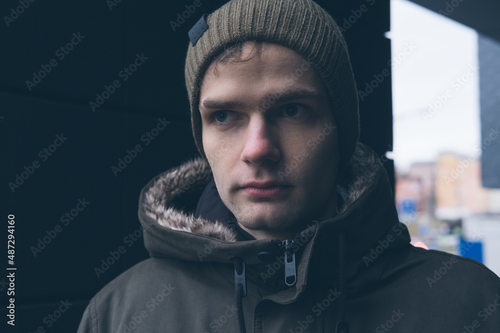 street portrait of a young handsome guy in a hat and jacket