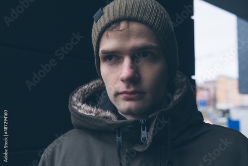 Obraz na płótnie street portrait of a young handsome guy in a hat and jacket w salonie