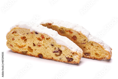 Sliced Traditional Christmas stollen cake with marzipan and dried fruit isolated on white background