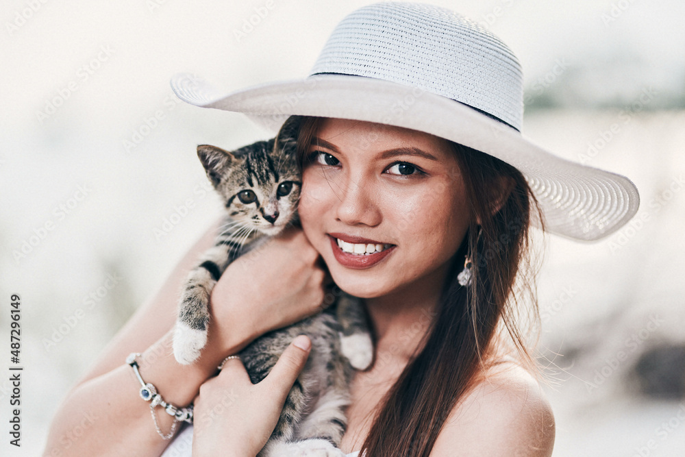Cute Asian female posing with her pet kitten