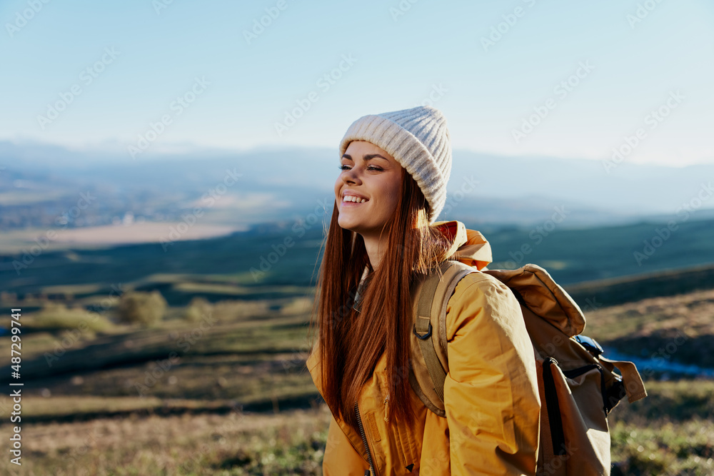 woman tourist in a yellow jacket in a hat backpack travel mountains relaxation woman tourist in a yellow jacket in a hat backpack travel mountains relaxation