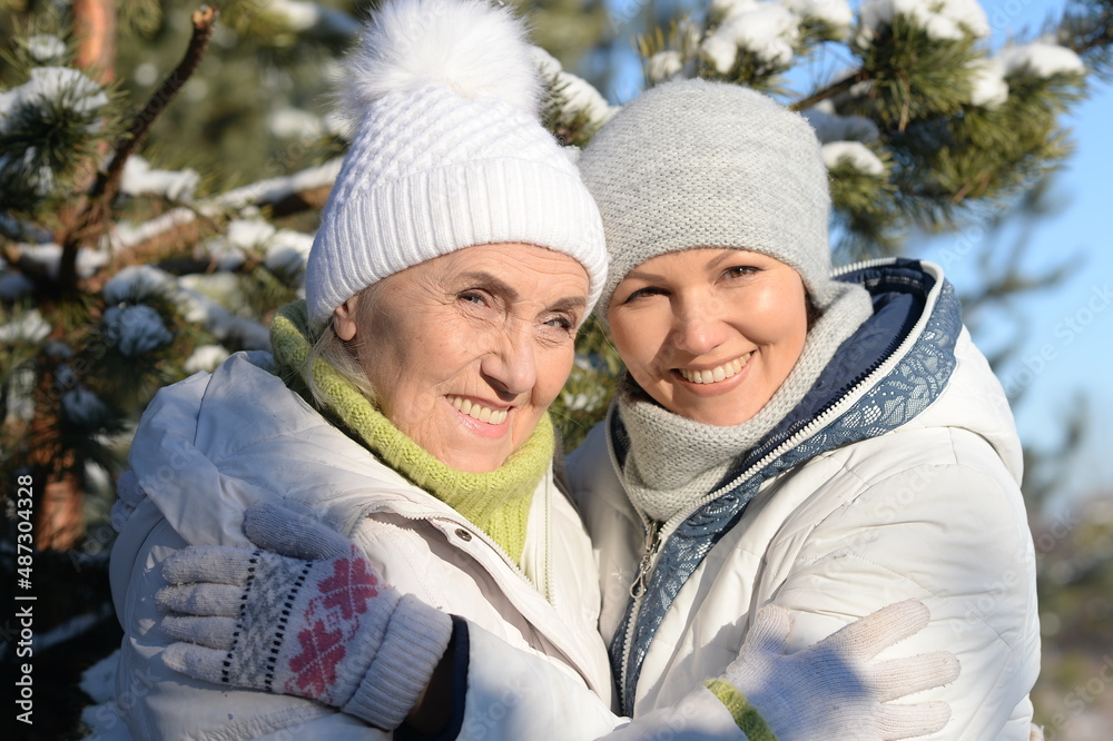 happy woman with mother in winter clothes posing outdoors happy woman with mother in winter clothes posing outdoors