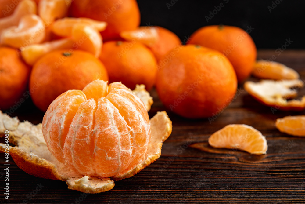 Mandarin with peeled slices on dark wooden background. Mandarin with peeled slices on dark wooden background.