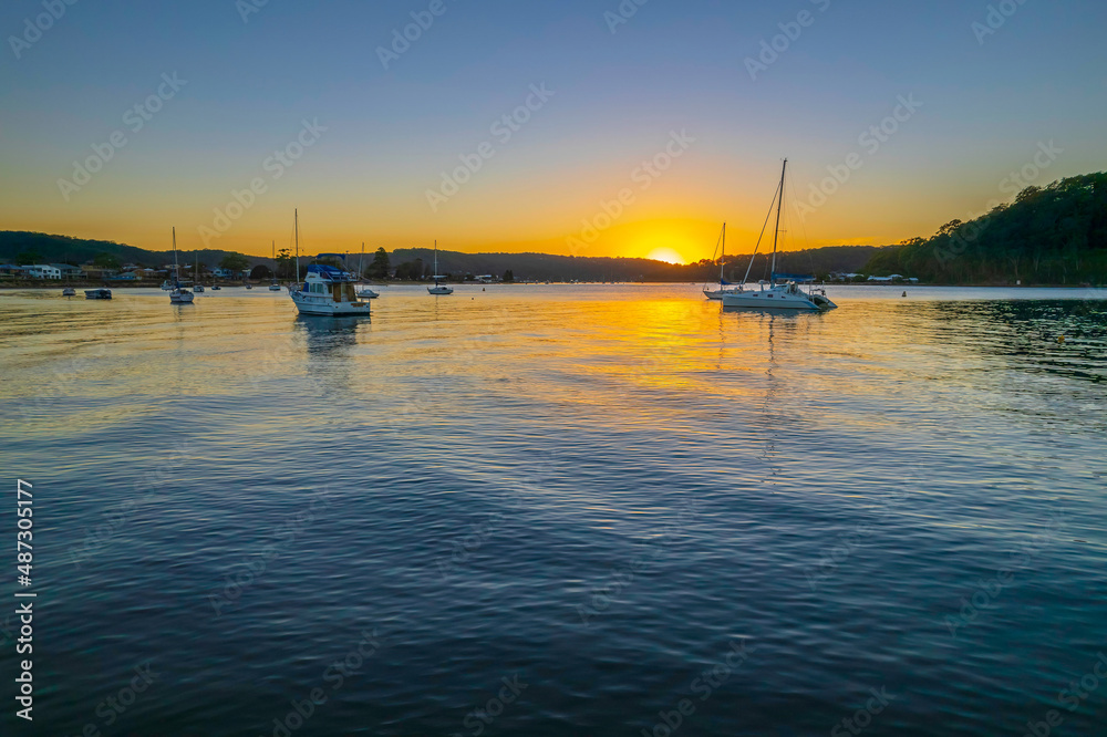 Aerial sunrise waterscape with boats and clear skies