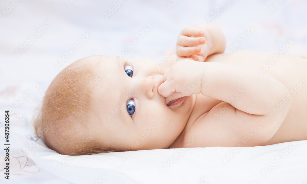 cute blue-eyed baby in her cozy white bed cute blue-eyed baby in her cozy white bed