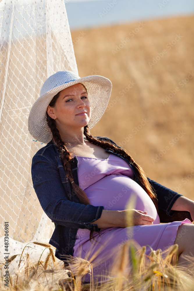 Obraz premium pregnant woman in a wheat field