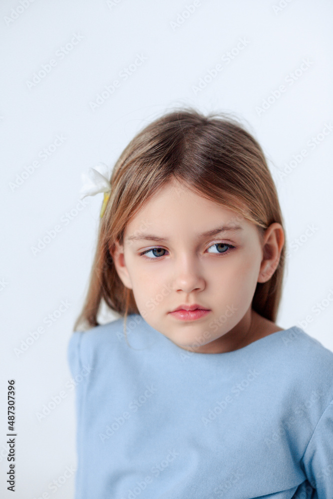 Naklejka premium A beautiful cheerful little girl about 7 years old in a beautiful dress on an isolated white background.A place for your text.