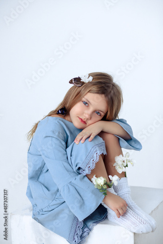 A beautiful cheerful little girl about 7 years old in a beautiful dress on an isolated white background.A place for your text.