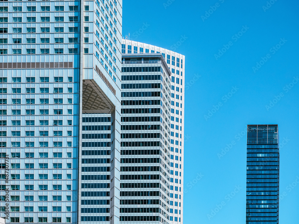 front view on modern white skyscrapers over blue sky background