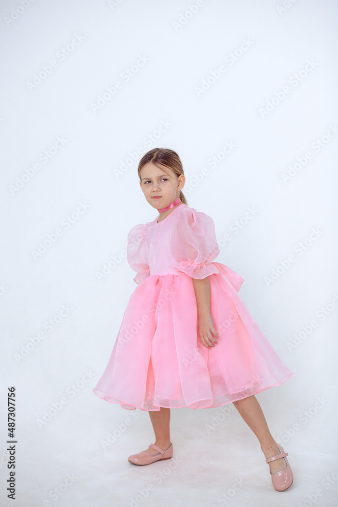 A beautiful cheerful little girl about 7 years old in a beautiful dress on an isolated white background.A place for your text. A beautiful cheerful little girl about 7 years old in a beautiful dress on an isolated white background.A place for your text.