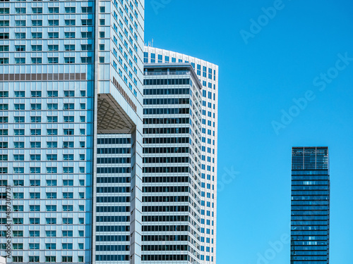 front view on modern white skyscrapers over blue sky background © lenaivanova2311