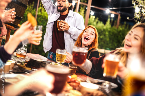 Canvas Print Young men and women having fun drinking out at beer garden patio - Social gather