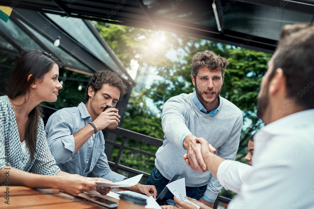 Obraz premium Glad you could join us today. Shot of businesspeople shaking hands during a meeting at a cafe.