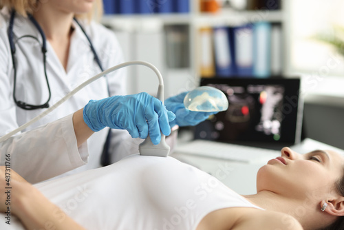 фотографія The doctor makes a woman breast ultrasound, blurry