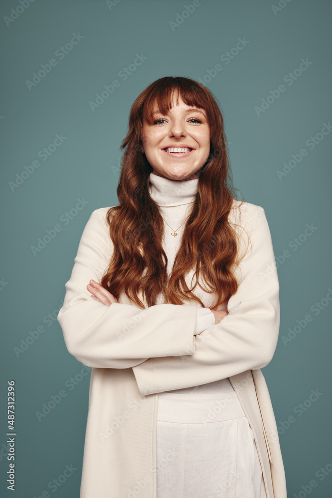 Cross-armed woman smiling cheerfully in a studio Cross-armed woman smiling cheerfully in a studio