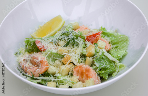 light dietary salad of leaves, red fish fillet, grated cheese croutons and dressing. The theme of proper and healthy nutrition, diet and weight loss