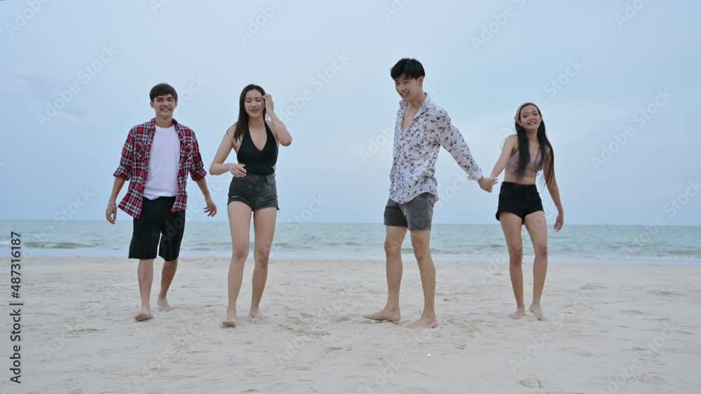 Young asian friends walking with jumping on the beach Young asian friends walking with jumping on the beach