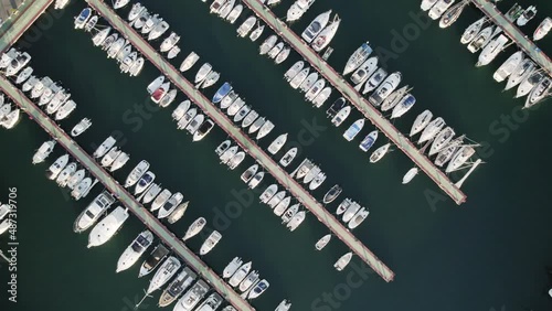 Vertical drone view of a mall sports nautical club showing several mooring rows with dozens of docked recreational boats next to each other in Oropesa Del Mar, Spain photo