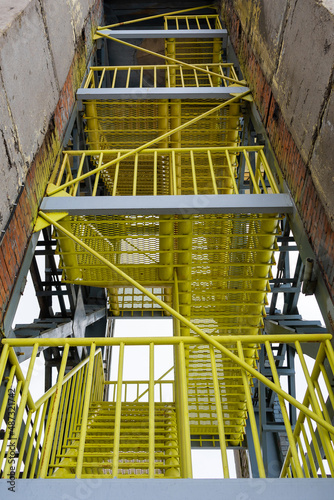 Yellow industrial stairs. Metal, production, mechanical engineering, technologies.