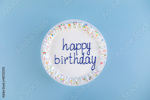 Canvas Print white cake with the inscription happy birthday on blue background, top view