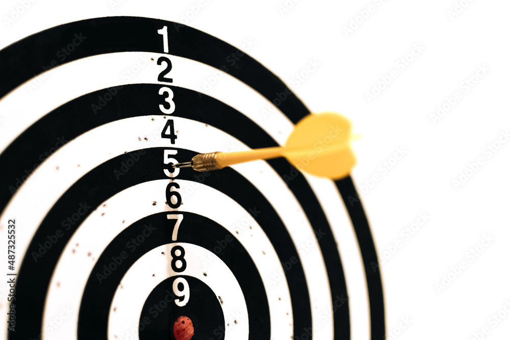 The yellow dart hit the target with the number five. An unsuccessful throw. The desire to win. Selective focus. The yellow dart hit the target with the number five. An unsuccessful throw. The desire to win. Selective focus.