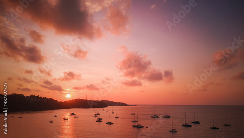 Marinas in the bay have many sailboats at sea with beautiful sunrise tropics in Phuket, Thailand.