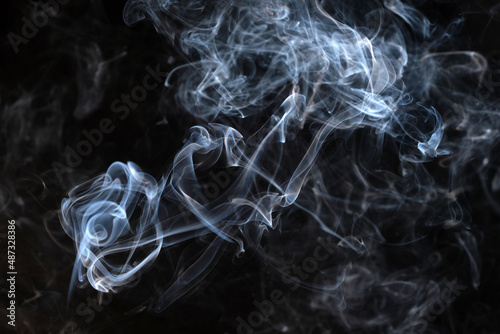 Twisted plumes of smoke, smoke movement on a black background. Abstract smoke lines