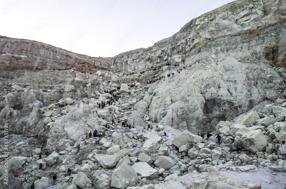Many people hiking on top of mountain or volcano. Tourists walking in the crater of a active volcano Many people hiking on top of mountain or volcano. Tourists walking in the crater of a active volcano