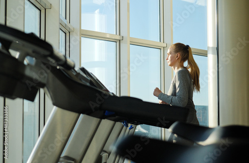 Woman of middle age working out in gym. Healthy lifestyle.Training on exercise machine. photo