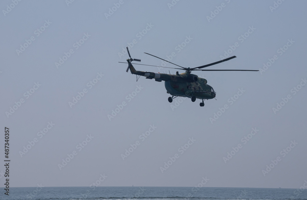 Fototapeta premium The military helicopter against the blue sky