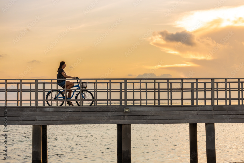 Obraz premium Middle aged woman with a bike on a bridge