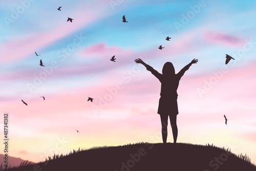 Woman rising hands and birds flying on sunset sky at nature field abstract background. Freedom feel good and travel adventure concept.