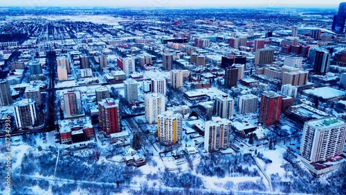 Downtown Edmonton Winter Westside Aerial hold at a semi birds eye view over the most luxurious residential properties with record snow covering the River Valley Park edge by the residential buildings photo